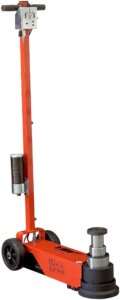 A red manual hydraulic floor jack with a vertical handle and black wheels on a white background.