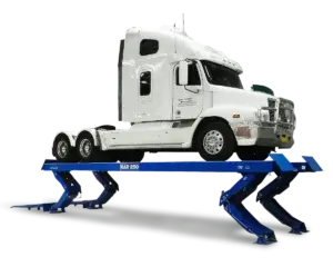 A white semi-truck is elevated on a blue vehicle lift against a white background.